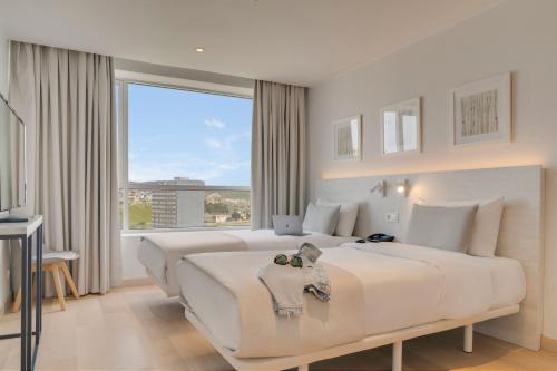 丹吉尔Pestana Tanger - City Center Hotel Suites & Apartments的白色的卧室设有一张大床和一个大窗户