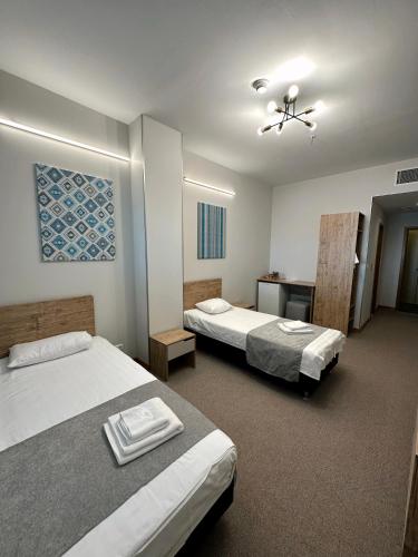 阿斯塔纳PORT INN Hotel的酒店客房配有两张床和一张书桌