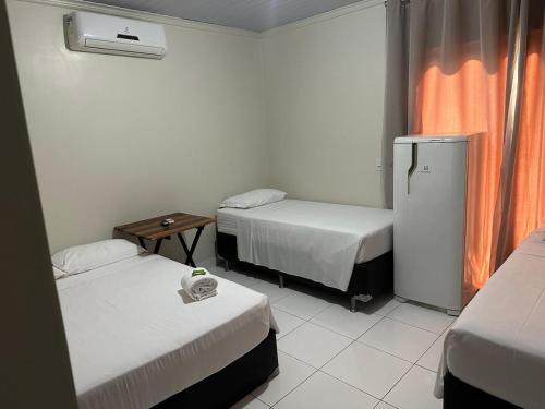 索里苏PRINCIPE HOTEL的酒店客房配有两张床和一台冰箱