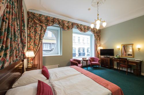 布拉格自由酒店的配有一张床、一张书桌和一扇窗户的酒店客房