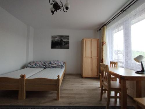 斯洛莫夫采维日奈Trzech Koron 16的一间卧室配有一张床、一张桌子和一张书桌