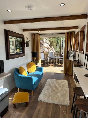 ForkillGreenvale Cabins的客厅配有蓝色的沙发和桌子