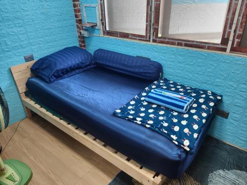 曼谷206 Quiet and Cozy Apartment的蓝色墙壁间的一张床位