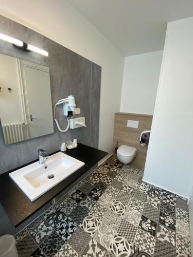 瑟堡卢浮宫酒店的一间带水槽和卫生间的浴室