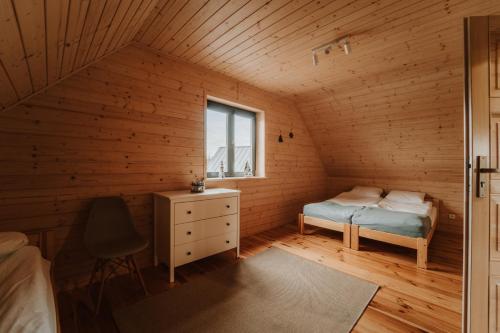 斯蒂格纳Morze Tu的一间设有一张床的卧室和木制房间的窗户
