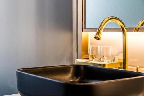 广州莱福仕行政公寓（广州正佳广场体育西路地铁站店）的厨房水槽配有金色水龙头和玻璃杯