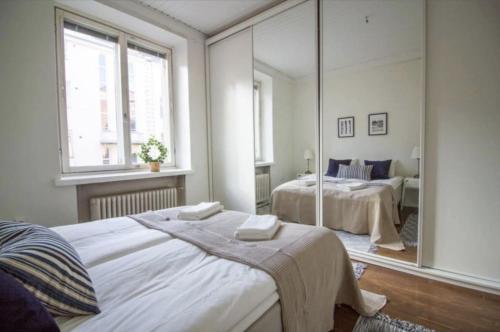 赫尔辛基2ndhomes Fabianinkatu Apartments的一间卧室设有两张床和大镜子