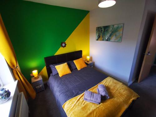 贝尔法斯特3br Cosy Modern Stay的一间卧室设有一张绿色和黄色墙壁的床