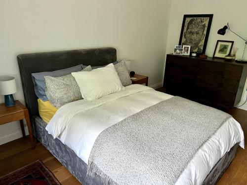 伦敦Urban Oasis Chic 1BR Flat with Spacious Garden的一间卧室配有带白色床单和枕头的床。