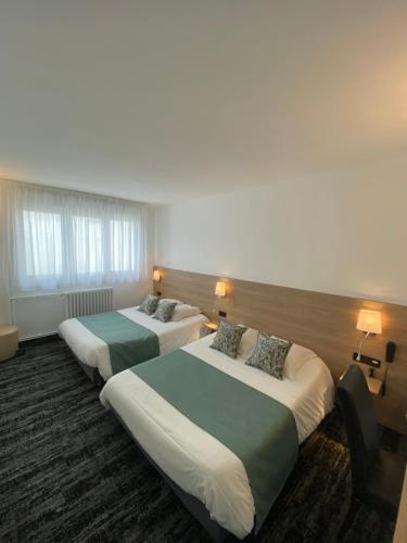 瑟堡卢浮宫酒店的酒店客房设有两张床和两盏灯。
