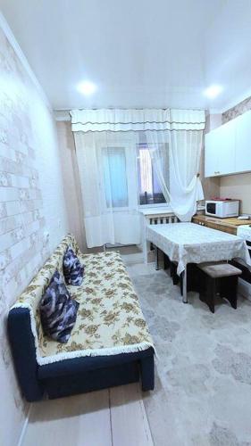 PrigorodnyyАэропорт Астана 5 минут юг1 233的客厅配有沙发和桌子