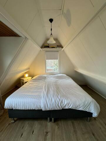 诺德韦克Hello Noordwijk - Tiny House Dahliastraat 60的阁楼卧室配有白色床