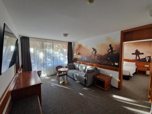 克拉尼斯卡戈拉考帕斯酒店的酒店客房带沙发以及一间卧室