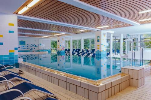 克拉尼斯卡戈拉考帕斯酒店的大楼内带椅子的大型游泳池