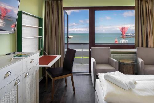 黑尔戈兰岛Insulaner Dependance的配有一张床、一张书桌和一扇窗户的酒店客房