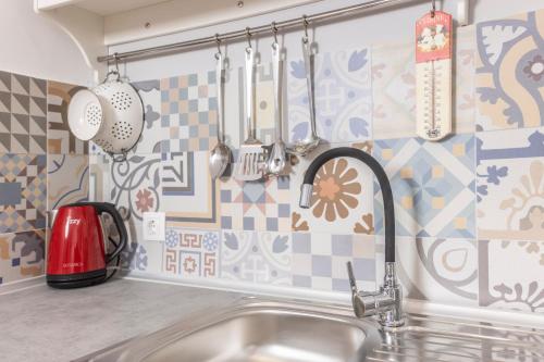 波利克罗诺BleVista Apartments的厨房配有水槽和墙上的餐具