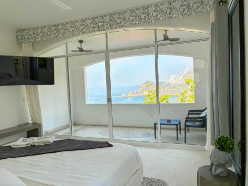 阿卡普尔科Villa de Reyes Hotel Boutique的卧室设有海景大窗户
