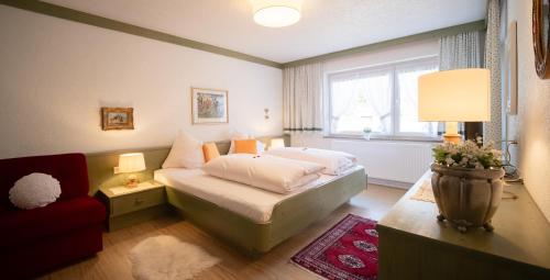 蒂罗尔-泽费尔德森林之家公寓的一间卧室配有一张床、一张沙发和一个窗口