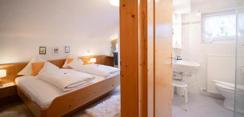 蒂罗尔-泽费尔德森林之家公寓的一间卧室配有床、水槽和卫生间