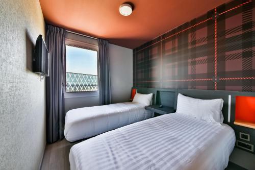 弗朗斯地区特朗布莱easyHotel Paris Charles de Gaulle Villepinte的酒店客房设有两张床和窗户。