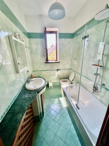 马萨鲁布朗斯Green Holiday House的带浴缸、盥洗盆和卫生间的浴室