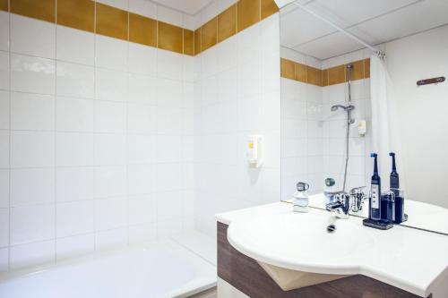 马恩河畔诺让马恩河畔诺让阿德吉奥阿克瑟斯公寓式酒店的白色的浴室设有水槽和浴缸。