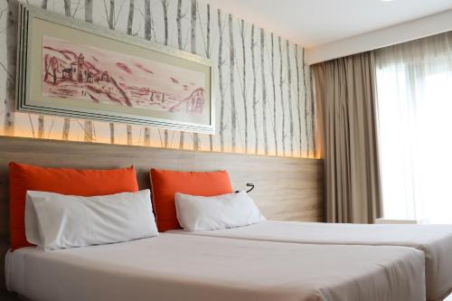 略夫雷加特河畔奥斯皮塔莱特巴塞罗那格伦薇亚菲拉欧洲酒店的配有橙色枕头的酒店客房内的两张床
