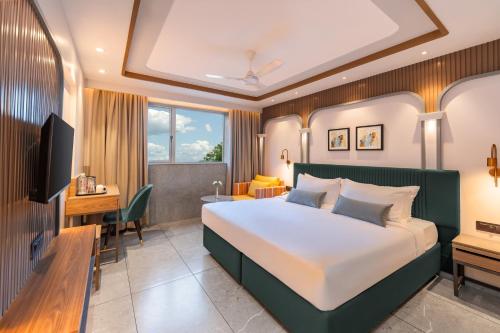 孟买Ajanta Continental-Mumbai Airport的配有一张床和一张书桌的酒店客房