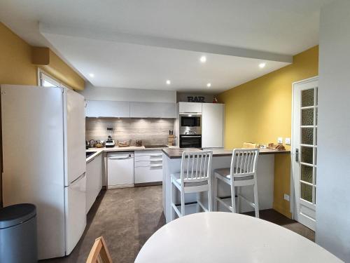 拉瓦勒Appartement et Maison Espace Mayenne的厨房配有白色冰箱和2把白色椅子