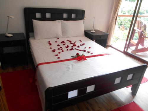 格劳德港Cashew Nut Grove Chalets的一张床上有一大堆红玫瑰