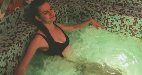 波朗特吕阿雪依Spa酒店的女人坐在热水浴缸里