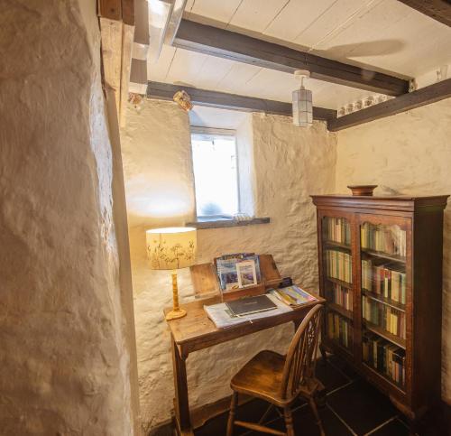 Saint NicholasTal y Gaer Cottage Goodwick的客房设有带椅子的书桌和窗户。