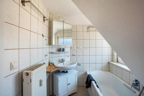 巴特维尔德巴德Schwarzwaldnest的浴室配有盥洗盆、镜子和浴缸