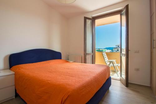 奥尔比亚Olbia Oasis Apartment with Two Balconies!的一间卧室配有一张带橙色床罩的床和一个阳台