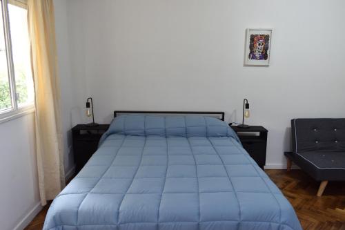布宜诺斯艾利斯Belgrano Cozy Suite的卧室内的一张蓝色棉被