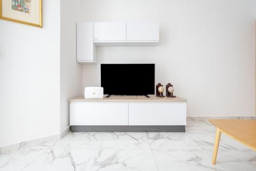姆西达Msida Central Suites的一间客厅,在白色的墙上配有电视