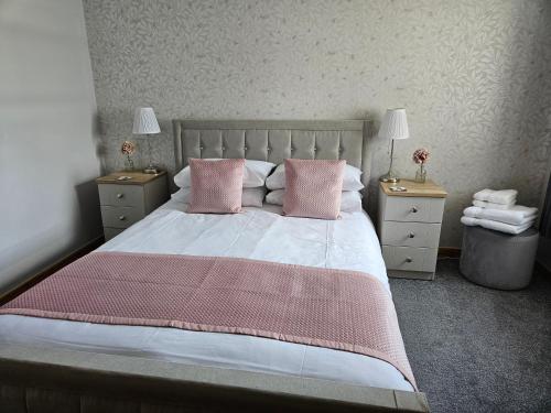 因弗内斯37 Farraline Court, City Centre apartment的卧室配有一张带粉红色枕头的大床