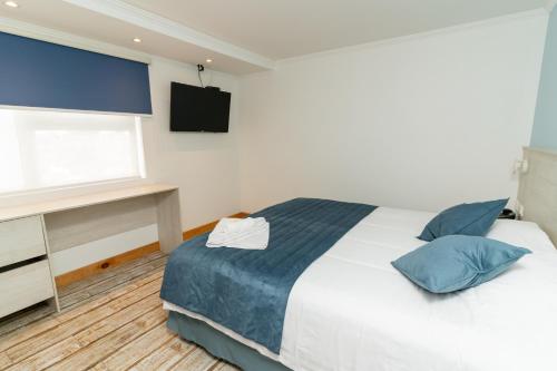 伊基克Hotel Mareblu Iquique的一间卧室设有一张床、一个窗口和一台电视