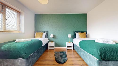 巴塞尔顿Stunning 3-Bed House in Basildon的绿墙客房内的两张床