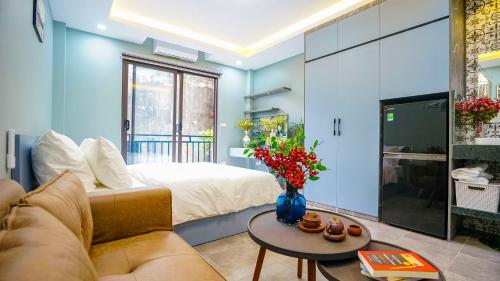 河内Hanoi Ben's Apartment and Hotel的客房设有床、沙发和桌子。