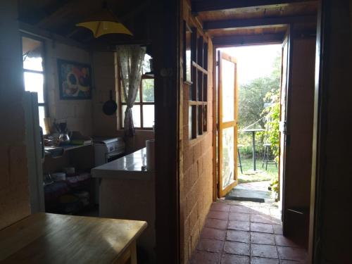 奥塔瓦洛Quinta El Quinde的厨房设有一扇门,可通往带桌子的厨房