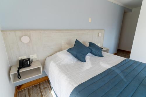 伊基克Hotel Mareblu Iquique的一间卧室配有一张带蓝色枕头的大床