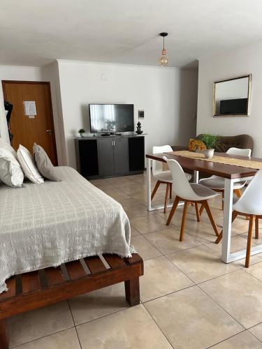科尔多瓦Dpto Paraná - Piscina, calefacción y aire acond的一间卧室配有一张床铺和一张桌子,还有一间用餐室