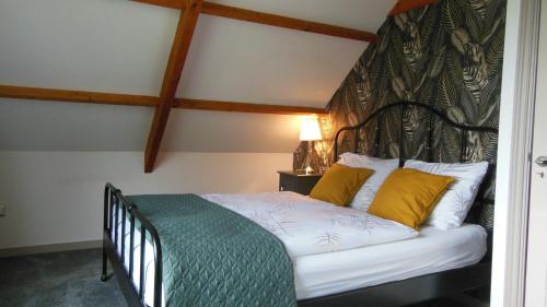 阿姆斯特丹Munnik's Hof的一间卧室配有一张带黑色床头板和黄色枕头的床。
