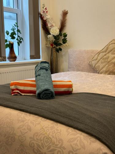 伦敦Forestroom的一张带两个枕头的床和花瓶