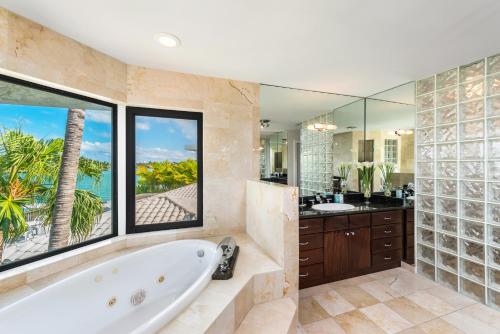 迈阿密Discover Serenity by the See Your Exclusive Miami Beach Escape!的带浴缸的浴室和大窗户