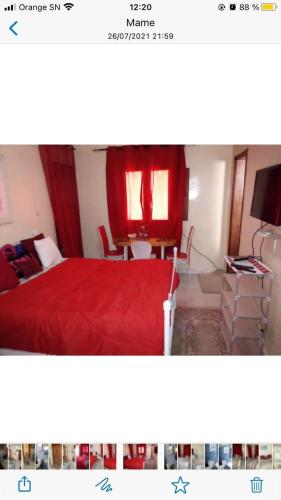 达喀尔Chez penda的一间卧室配有红色的床和桌椅