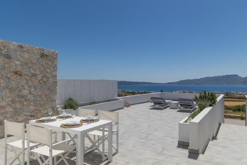 阿达玛斯CASA ANNA LOFT Boutique House with Full Sea View的一个带白色桌椅的海景庭院
