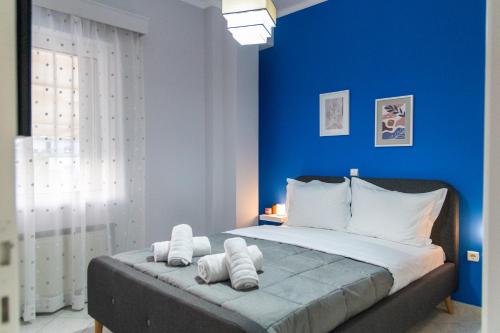 阿尔戈斯50 DANAIDES的蓝色卧室配有一张带白色枕头的大床