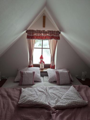 日茄基Chalupa U Křížku Říčky v Orlických horách的卧室配有带枕头的床铺和窗户。
